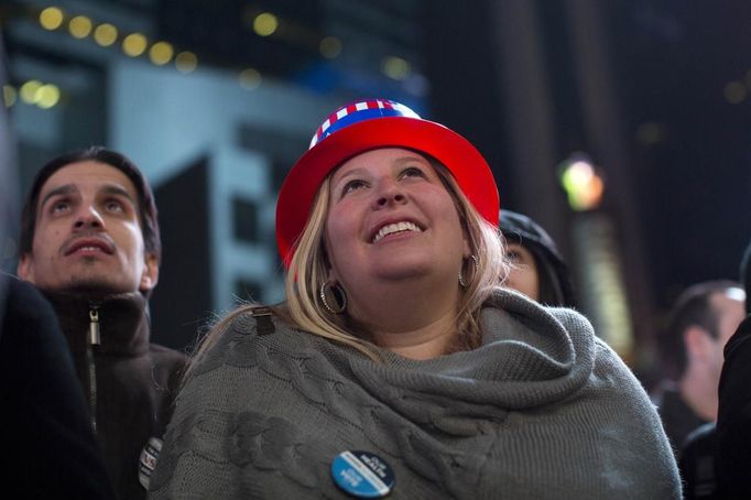 Rozradostnění Američané na Times Square v New Yorku pozorují na multimediálních panelech vítězný projev prezidenta USA Baracka Obamy.