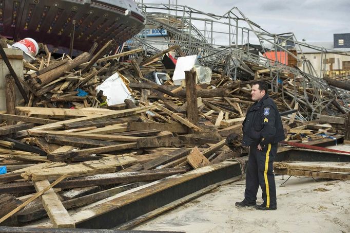 A Seaside Heights police officer looks over damage to the FunTown Amusement Pier three days after Hurricane Sandy came ashore in Seaside Heights, New Jersey, November 1, 2012. At least 82 people in North America died in the superstorm, which ravaged the northeastern United States on Monday night, and officials said the count could climb higher as rescuers searched house-to-house through coastal towns. REUTERS/Steve Nesius (UNITED STATES - Tags: ENVIRONMENT DISASTER) Published: Lis. 1, 2012, 5:54 odp.