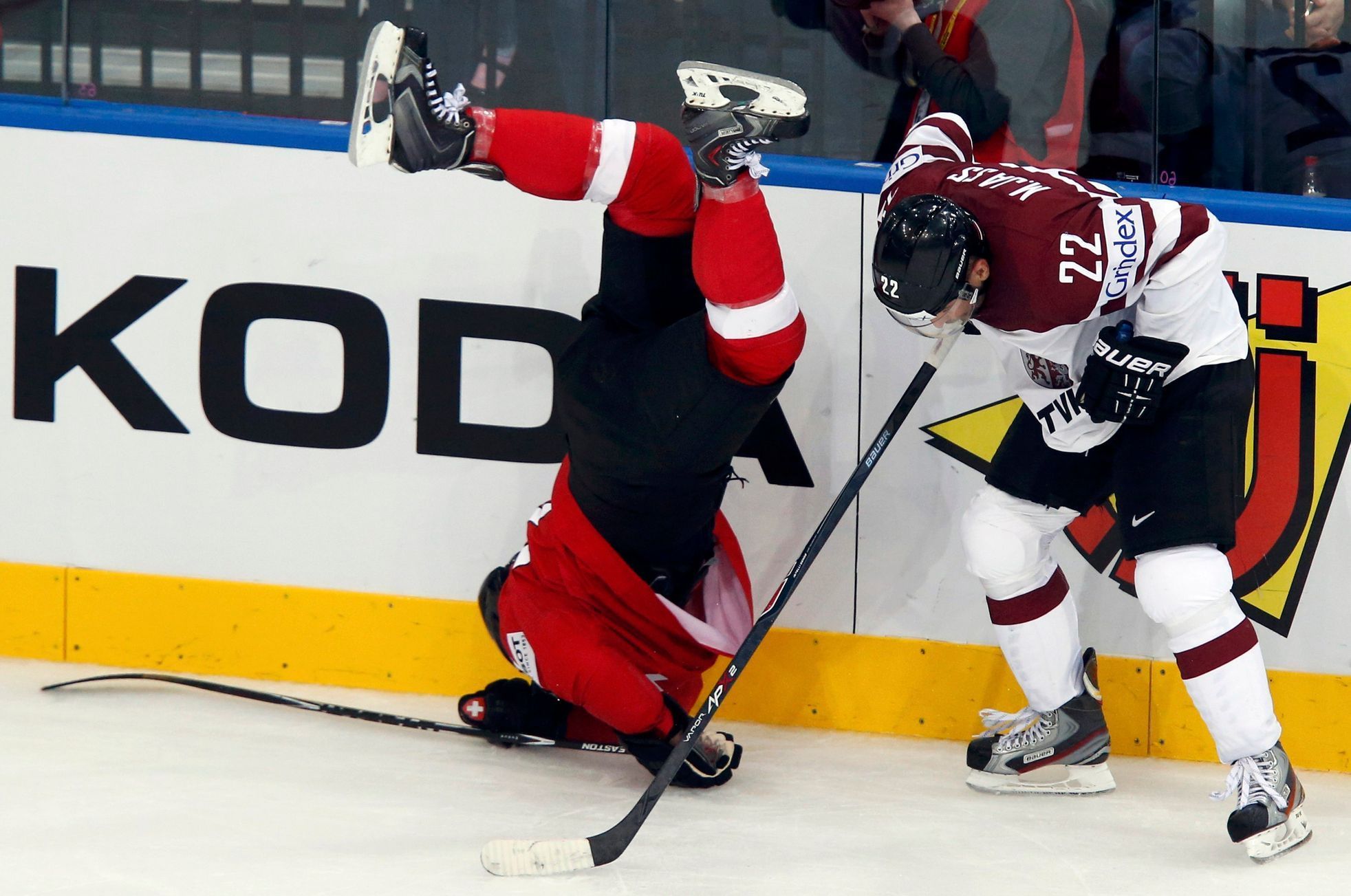 Switzerland's Weber falls after a collision with Latvia's Jass during the third period of their men's ice hockey World Championship Group B game at Minsk Arena in Minsk