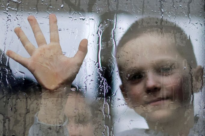 Ukrajinský chlapec se loučí s otcem. Mává z okna vlaku, který odjíždí ze Záporoží.