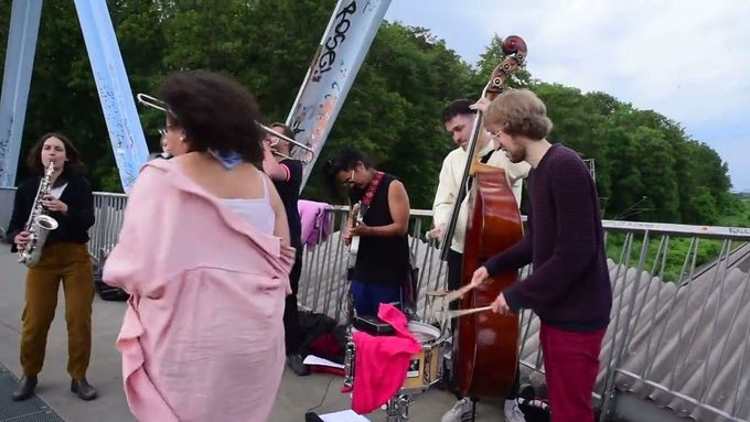 Luise Volkmann se svou kapelou na mostě hrají coververzi Theme de Yoyo z repertoáru Art Ensemble of Chicago.