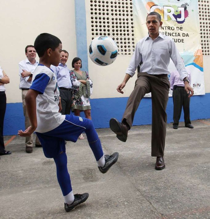 Obama hraje fotbal s mýstními chlapci v Ciudad de Deus Favela.