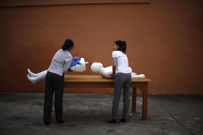 Students carry pieces of a plastic mannequin to be used for an undertaker service class at the Tianquanjiajing Funeral Service school in Jiaxing, Zhejiang province May 29, 2012. A new breed of young Chinese undertakers are fighting centuries-old taboos to gain social acceptance for their profession, saying they help the deceased and their families make their final parting with respect. There are more than 1,500 students across the country studying to become undertakers each year. Courses in funeral services take three years to complete and the service includes washing of the dead body as well as providing funeral make-up and dressing. Picture taken May 29, 2012. REUTERS/Carlos Barria (CHINA - Tags: SOCIETY) ATTENTION EDITORS - PICTURE 09 OF 17 FOR PACKAGE 'FUNERAL SERVICE STUDENTS' Published: Čer. 7, 2012, 2:44 dop.