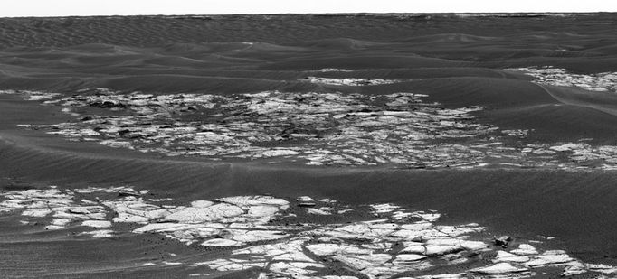 'Erebus Crater' on the Horizon 9/26/05 This is a mosaic assembled from some of the images taken by the panoramic camera on NASA's Mars Exploration Rover Opportunity during the rover's 590th sol (Sept. 21, 2005). The view is toward the south and includes rock exposures north of "Erebus Crater," with the crater in the background. The rover will investigate the exposed rocks in the foreground and will take additional panoramic-camera images of Erebus Crater, which is about 300 meters (about 984 feet) across. Erebus Crater dwarfs the landing-site crater, "Eagle Crater," which measures about 22 meters (72 feet) in diameter. And, it is nearly twice the diameter of "Endurance Crater," which, at 130 meters (430 feet) wide, has been compared to a stadium. The camera's red filter was used for taking the images in this mosaic. It admits light with a wavelength of 750 nanometers. Image Credit: NASA/JPL-Caltech/Cornell