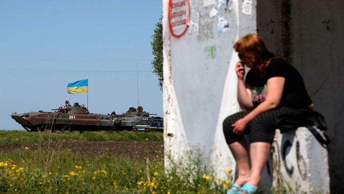 Žena sleduje ukrajinské jednotky v Mariupolu na východě Země.