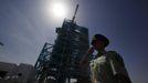 A soldier salutes in front of the launch pad holding the Long March II-F rocket loaded with Shenzhou-9 manned spacecraft, in Jiuquan Satellite Launch Center, Gansu province, June 16, 2012. China will send its first woman into outer space this week, prompting a surge of national pride as the rising power takes its latest step towards putting a space station in orbit within the decade. Liu Yang, a 33-year-old fighter pilot, will join two other astronauts aboard the Shenzhou 9 spacecraft when it lifts off from a remote Gobi Desert launch site on Saturday evening. REUTERS/Jason Lee (CHINA - Tags: SCIENCE TECHNOLOGY MILITARY) Published: Čer. 16, 2012, 4:14 dop.