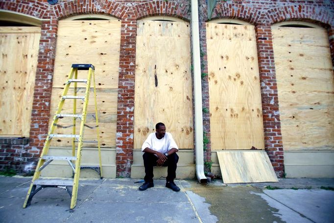 James Cardoza takes a break after helping his boss board up his business in preparation for tropical storm Isaac in New Orleans, Louisiana August 27, 2012. REUTERS/Sean Gardner (UNITED STATES - Tags: ENVIRONMENT) Published: Srp. 27, 2012, 9:26 odp.