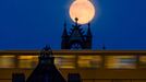 The supermoon rises behind Oberbaum Bridge as a train passes through in Berlin