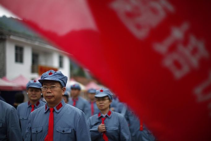 Mid-level government officials dressed in red army uniforms walk into an old house where former Chinese leader Mao Zedong used to live during their 5 days training course at the communist party school called China Executive Leadership Academy of Jinggangshan, in Jiangxi province, in this September 21, 2012 file photo. China's Communist Party has dramatically stepped up its training of the country's roughly 40 million party and government officials in the past decade. With public scrutiny of cadre behaviour growing via social media, the party is likely to call for continued, and deepened, cadre education at the upcoming 18th Party Congress. At the vanguard of this education drive, alongside a Central Party School in Beijing, are three "Executive Leadership Academies" which opened in 2005 for middle-ranking and senior officials in Shanghai, Yan'an and Jinggangshan. The curriculum covers Marxism, Leninism and Mao Zedong Thought, but students may also take finance courses, receive in-depth media training or role-play crisis management scenarios on everything from disease outbreaks to train wrecks. REUTERS/Carlos Barria/Files (CHINA - Tags: POLITICS SOCIETY) Published: Zář. 24, 2012, 2:43 odp.