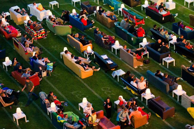 People sit on sofas as they watch the opening game of the 2014 World Cup between Brazil and Croatia, during a public viewing event at the Alte Foersterei stadium in Berli