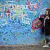 Lennonova zeď po třech měsících od malování - turisté, graffiti
