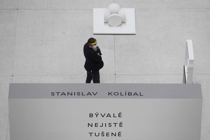 Pracovník Národní galerie s respirátorem a ochranným štítem na výstavě děl Stanislava Kolíbala ve Veletržním paláci.