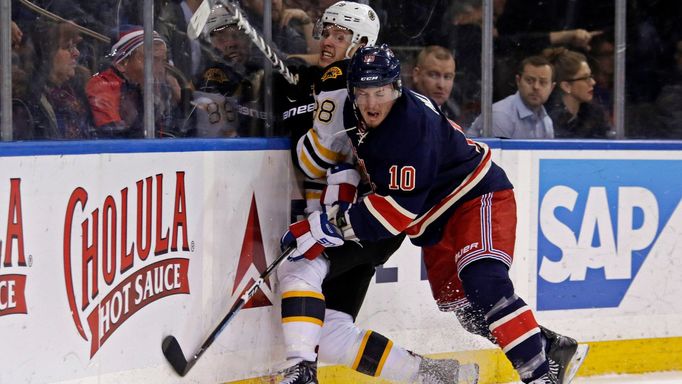 New York Rangers center J.T. Miller (10) checks Boston Bruins left wing David Pastrnak (88)