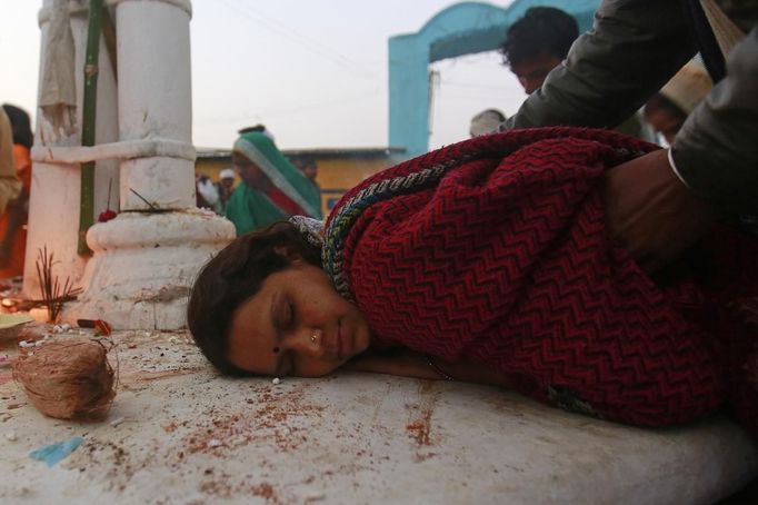 A devotee who is believed to be possessed by evil spirits lies on a sacred platform at Guru Deoji Maharaj temple during a ghost fair at Malajpur village in Betul district in the central Indian state of Madhya Pradesh January 26, 2013. People from across India come to this fair to be exorcised of �evil spirits�. They are usually brought by relatives and they are most often women. The exorcism involves running around the temple courtyard to make the 'ghost' weak then being beaten by a priest with a broom. Picture taken January 26, 2013. REUTERS/Danish Siddiqui (INDIA - Tags: SOCIETY RELIGION) ATTENTION EDITORS: PICTURE 14 OF 24 FOR PACKAGE 'INDIAN GHOSTBUSTERS' SEARCH 'INDIA GHOST' FOR ALL IMAGES Published: Úno. 5, 2013, 5:09 dop.