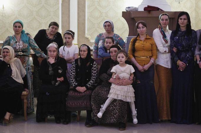 Women watch dancing at a wedding party in the Chechen capital Grozny April 24, 2013. The naming of two Chechens, Dzhokhar and Tamerlan Tsarnaev, as suspects in the Boston Marathon bombings has put Chechnya - the former site of a bloody separatist insurgency - back on the world's front pages. Chechnya appears almost miraculously reborn. The streets have been rebuilt. Walls riddled with bullet holes are long gone. New high rise buildings soar into the sky. Spotless playgrounds are packed with children. A giant marble mosque glimmers in the night. Yet, scratch the surface and the miracle is less impressive than it seems. Behind closed doors, people speak of a warped and oppressive place, run by a Kremlin-imposed leader through fear. Picture taken April 24, 2013. REUTERS/Maxim Shemetov (RUSSIA - Tags: SOCIETY POLITICS RELIGION) ATTENTION EDITORS: PICTURE 15 OF 40 FOR PACKAGE 'INSIDE MODERN CHECHNYA'. SEARCH 'REBUILDING CHECHNYA' FOR ALL IMAGES Published: Kvě. 1, 2013, 7:51 dop.