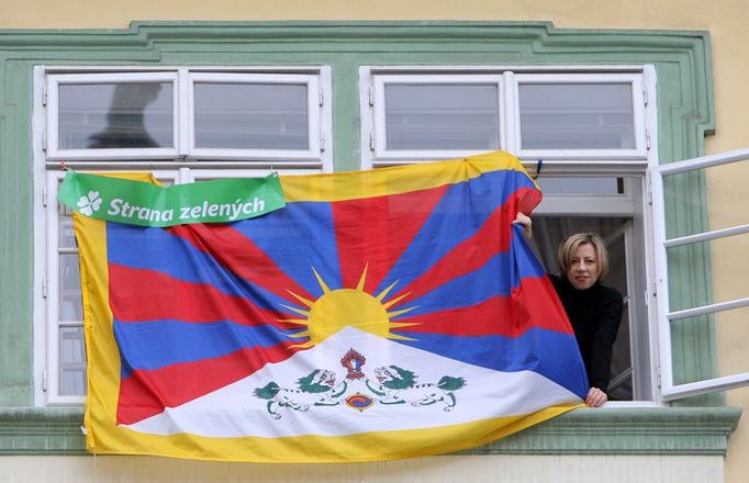 Poslankyně Kateřina Jacques v okně vedle tibetské vlajky, kterou poslanci Strany zelených vyvěsili na okna kanceláří poslaneckého klubu Sněmovny.