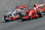Felipe Massa s Ferrari (vpravo) předjíždí v úvodu Velké ceny Maďarska vítěze kvalifikace Lewise Hamiltona.