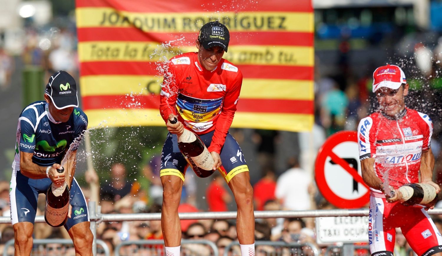 Španělský cyklista Alberto Contador (uprostřed) slaví vítězství ve Vueltě 2012 po poslední etapě 2012. Vlevo je druhý Alejandro Valverde a vpravo třetí Joaquim Purito Rodriguez.
