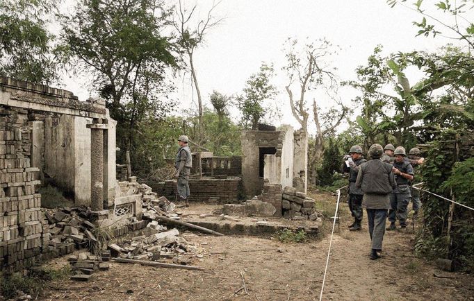 Američtí vojáci si prohlížejí zbytky domu ve vesnici My Lai v Jižním Vietnamu na snímku z 8. ledna 1970. Kolorovaný snímek