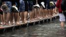 Tourists walk on raised platforms for flood waters in St. Mark Square during a period of seasonal high water in Venice October 27, 2012. The water level in the canal city rose to 127 cm (50 inches) above the normal level, according to the monitoring institute. REUTERS/Manuel Silvestri (ITALY - Tags: ENVIRONMENT SOCIETY TRAVEL) Published: Říj. 27, 2012, 12:35 odp.