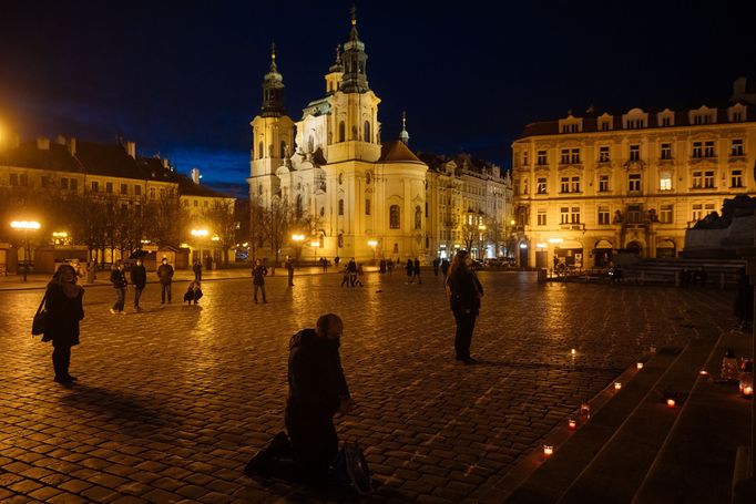 Lidé na Staroměstském náměstí v Praze spontánně uctívají oběti pandemie u křížů, které zde křídou nakreslila iniciativa Milion chvilek pro demokracii. 24 - 25. 3. 2021