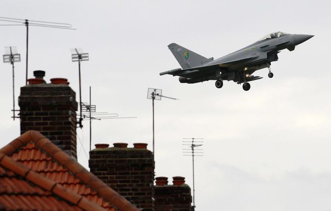 A Typhoon jet flies over homes in Hillingdon en route to RAF Northolt in west London in a May 6, 2012 file photo. Britain imposes a restriction on the airspace over London on Saturday ahead of the Olympic Games which start in a fortnight with a warning that planes that stray into the zone could ultimately be shot down. All planes, from commercial airliners to small single-seater craft, hand gliders and even model aircraft must adhere to strict regulations to fly across much of southeast England. REUTERS/Luke MacGregor/files (BRITAIN - Tags: TRANSPORT MILITARY SPORT OLYMPICS CIVIL UNREST) Published: Čec. 13, 2012, 12:40 odp.