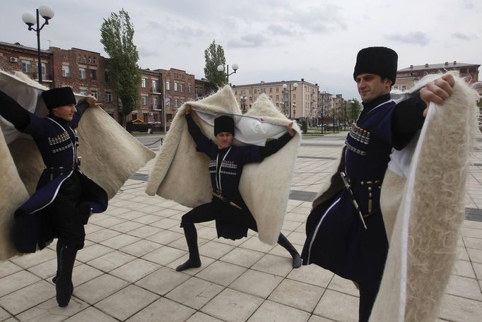 Members of a Chechen dance group pose for photographers at a government-organised event marking Chechen language day in the centre of the Chechen capital Grozny April 25, 2013. The naming of two Chechens, Dzhokhar and Tamerlan Tsarnaev, as suspects in the Boston Marathon bombings has put Chechnya - the former site of a bloody separatist insurgency - back on the world's front pages. Chechnya appears almost miraculously reborn. The streets have been rebuilt. Walls riddled with bullet holes are long gone. New high rise buildings soar into the sky. Spotless playgrounds are packed with children. A giant marble mosque glimmers in the night. Yet, scratch the surface and the miracle is less impressive than it seems. Behind closed doors, people speak of a warped and oppressive place, run by a Kremlin-imposed leader through fear. Picture taken April 25, 2013. REUTERS/Maxim Shemetov (RUSSIA - Tags: SOCIETY POLITICS RELIGION) ATTENTION EDITORS: PICTURE 11 OF 40 FOR PACKAGE 'INSIDE MODERN CHECHNYA'. SEARCH 'REBUILDING CHECHNYA' FOR ALL IMAGES Published: Kvě. 1, 2013, 7:39 dop.