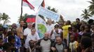 French swimmer Philippe Croizon (C in wheelchair) is joined by crew and Papuan residents after his arrival at the coastal village of Pasar Skow located in Indonesia's eastern province of Papua on May 17, 2012. Croizon, 43, who lost his limbs in an accident braved strong winds and currents to swim from Papua New Guinea to Indonesia on May 17, in the first stretch of a mission to swim between five continents. Croizon, who uses prosthetic limbs with flippers attached took seven and a half hours for the 20 kilometre (12-mile) journey.