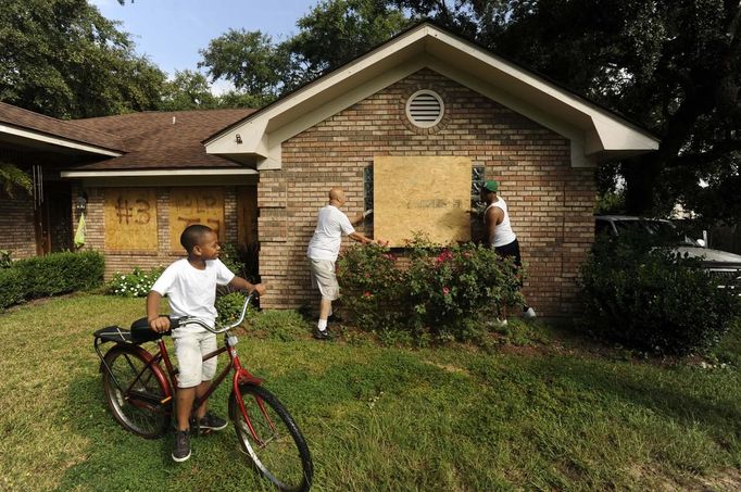 Kemari McBride watches his grandfather Purvis McBride and neighbor Fredrick Wright board up their home in as Hurricane Isaac approaches the coast in Gulfport, Mississippi, August 28, 2012. REUTERS/Michael Spooneybarger (UNITED STATES) Published: Srp. 28, 2012, 5:34 odp.