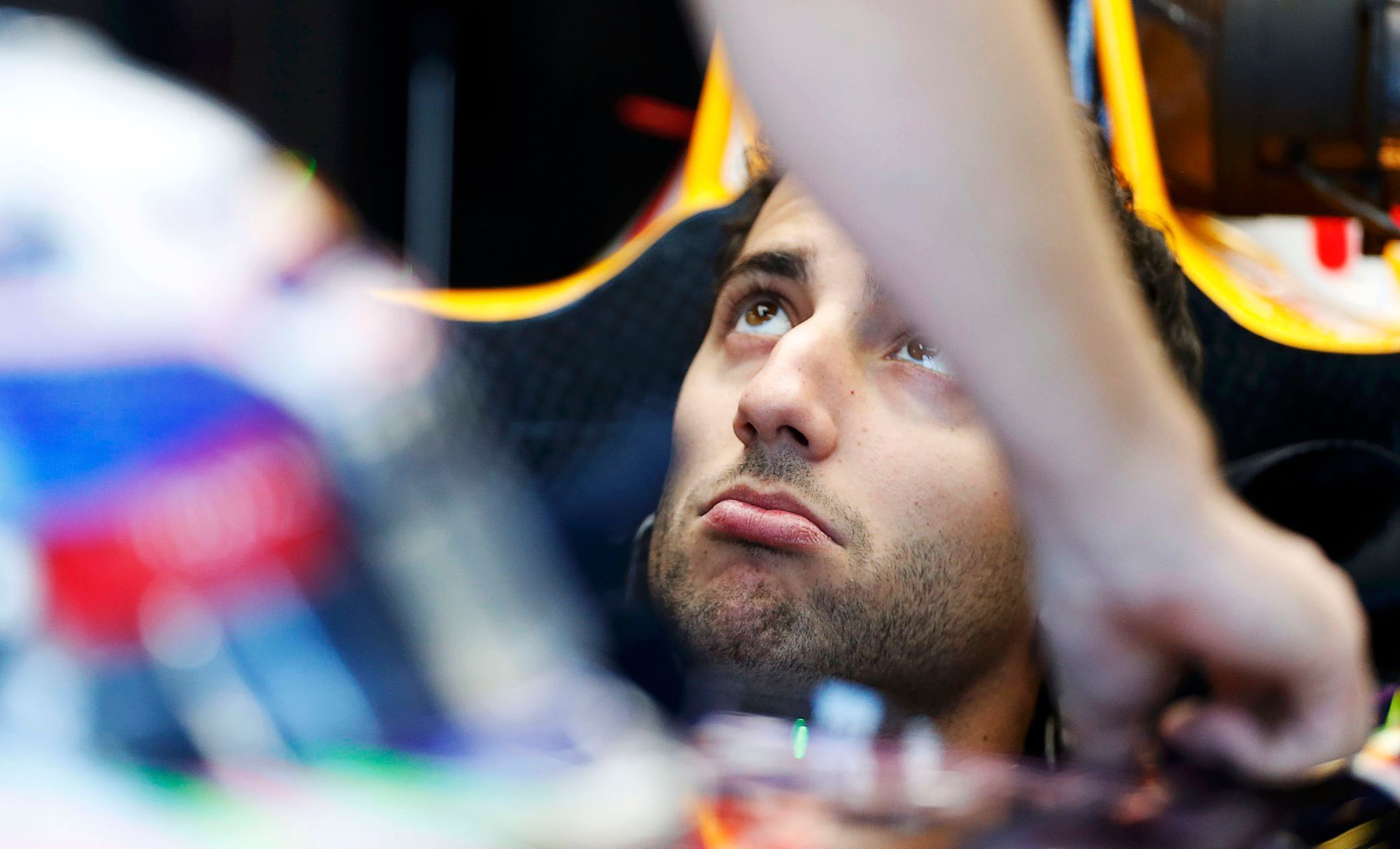 Red Bull Formula One driver Daniel Ricciardo of Australia looks up from his car in the team garage during the first practice session of the Australian F1 Grand Prix at the Albert Park circuit in Melbo