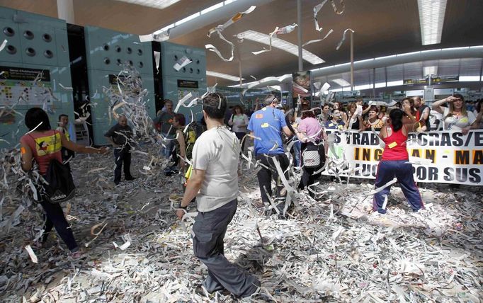 Cleaning staff workers toss pieces of papers during a protest at Barcelona's airport May 29, 2012. Cleaning staff working for a company who have a contract with the airport demonstrated against pay and benefits cuts made by their employer. REUTERS/Albert Gea (SPAIN - Tags: CIVIL UNREST BUSINESS TRANSPORT TPX IMAGES OF THE DAY) Published: Kvě. 29, 2012, 9:52 odp.