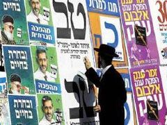 Orthodoxní Žid vylepuje předvolební plakát vyzývající k neúčasti v úterních volbách.