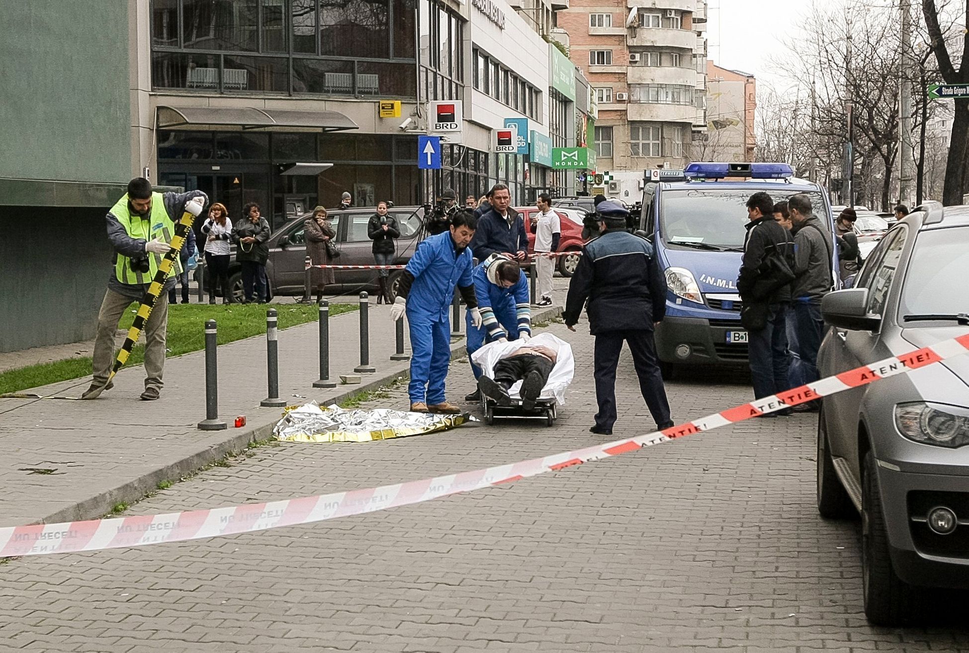 Záchranáři převážejí tělo Mattea Cassaniho od budovy Enelu v Bukurešti