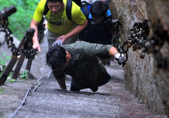 HUAYIN, CHINA - AUGUST 13: (CHINA OUT) Legless man Chen Zhou climbs the Huashan Mountain on August 13, 2012 in Huayin, Shaanxi Province of China. Legless 29-year-old man Chen Zhou from Cangshan of Shandong Province spent two days, 19 hours in total, climbing by arms to the top of Huashan Mountain. Chen lost his legs after falling off a train at the age of 13, but he has since strived to be stronger and joined in many public performances to encourage other people. Chen Zhou will climb the Taishan Mountain in Shandong province in the following months. ( automatický překlad do češtiny )