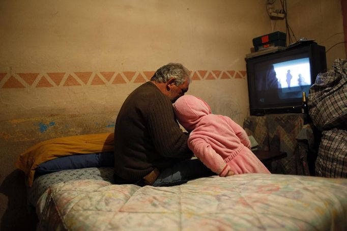 Agustin Gabarri (L) talks to his grandson Israel on the last night they slept at Gabarri's home before its demolition the following day at the Spanish gypsy settlement of Puerta de Hierro outside Madrid February 14, 2012. Fifty-four families have been living in Puerta de Hierro, on the banks of the Manzanares river for over 50 years. Since the summer of 2010, the community has been subject to evictions on the grounds that the dwellings are illegal. Families whose houses have been demolished, move in with relatives whose houses still remain while the debris keeps piling up around them as more demolitions take place. Picture taken February 14, 2012. REUTERS/Susana Vera (SPAIN - Tags: SOCIETY) ATTENTION EDITORS - PICTURE 13 OF 31 FOR PACKAGE 'GYPSY SITE DEMOLISHED' SEARCH 'GYPSY SITE' FOR ALL IMAGES Published: Lis. 5, 2012, 4:11 odp.