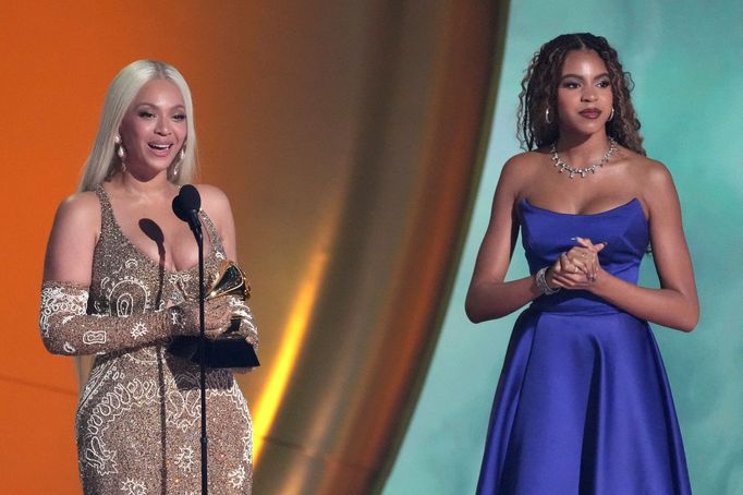 Zpěvačka Beyoncé (vlevo) přebírá Grammy pro album roku.