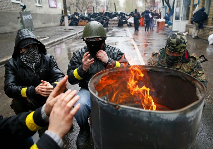 Pro-Russian men gather around a fire at a barricade near the police headquarters in Slaviansk April 13, 2014.