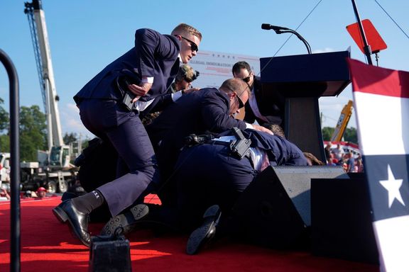 Další snímek, který během atentátu zachytil Evan Vucci. Trump se záhy po zásahu sklonil k zemi a přispěchalo k němu pět agentů tajné služby.