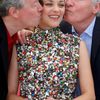 Directors Luc and Jean-Pierre Dardenne kiss cast member Marion Cotillard as they pose during a photocall for the film &quot;Deux jours, une nuit&quot; in competition at the 67th Cannes Film Festival i