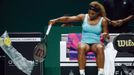 Serena Williams of the U.S. takes the plastic cover off a new racquet after smashing her first one during her WTA Finals singles semi-finals tennis match against Caroline