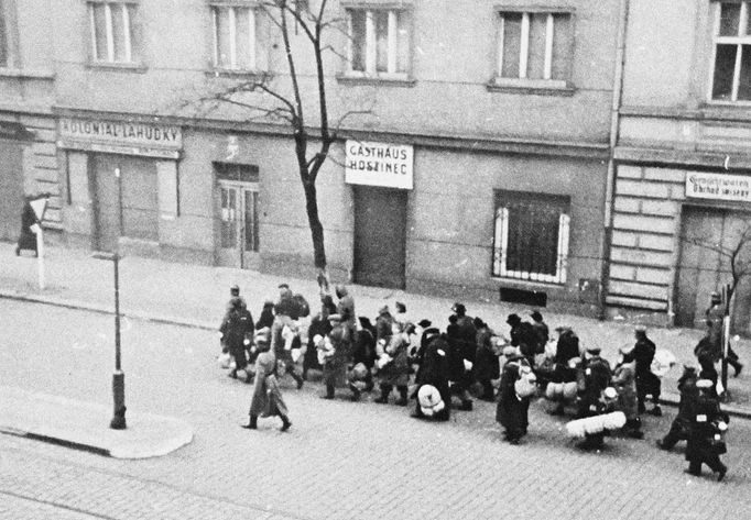 Snímek zachycující jdoucí židovský transport křižovatkou U Smaltovny nedaleko nádraží Praha Bubny v Praze.