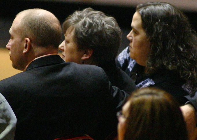 L-R: Aaron Poland, Mary Janice Poland and Lydia Hancock, son, wife and daughter of murdered bus driver Charles Albert Poland Jr., listen to a speaker at the funeral for Poland Jr. at Ozark Civic Center, near Midland City, Alabama, February 3, 2013. Mourners in the small town of Midland City, Alabama, gathered on Sunday to bury a school bus driver slain during the abduction of a child taken captive and held for a sixth day by a gunman in an underground bunker. REUTERS/Phil Sears (UNITED STATES - Tags: CRIME OBITUARY) Published: Úno. 4, 2013, 12:41 dop.