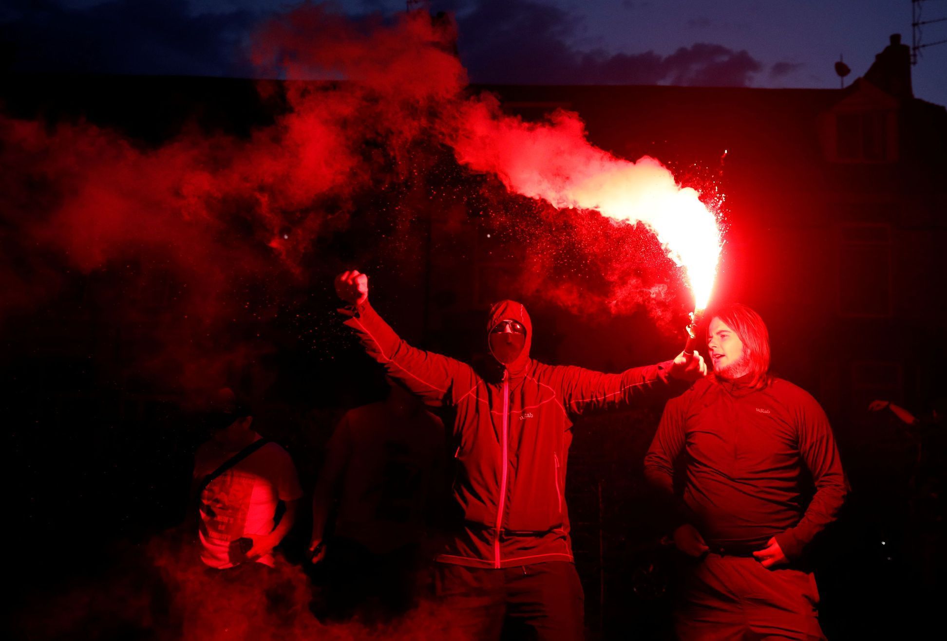 Fanoušci Liverpoolu oslavují před stadionem Anfield Road na dálku titul v Premier League