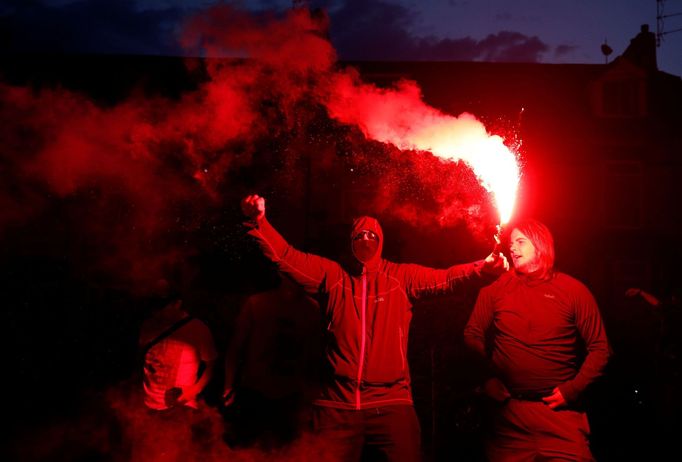 Fanoušci Liverpoolu oslavují před stadionem Anfield Road na dálku titul v Premier League.