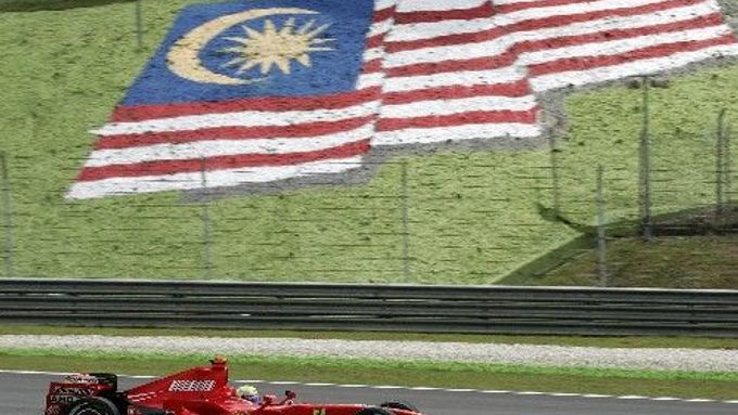 Pilot formule jedna Felipe Massa ze stáje Ferrari projíždí kolem malajské vlajky při tréninku na VC v Sepangu.
