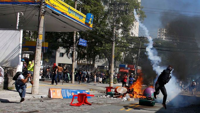 A demonstrator throws a tear gas bomb after military police shot at demonstrators during a protest against the 2014 World Cup, in Sao Paulo June 12, 2014. REUTERS/Nacho D