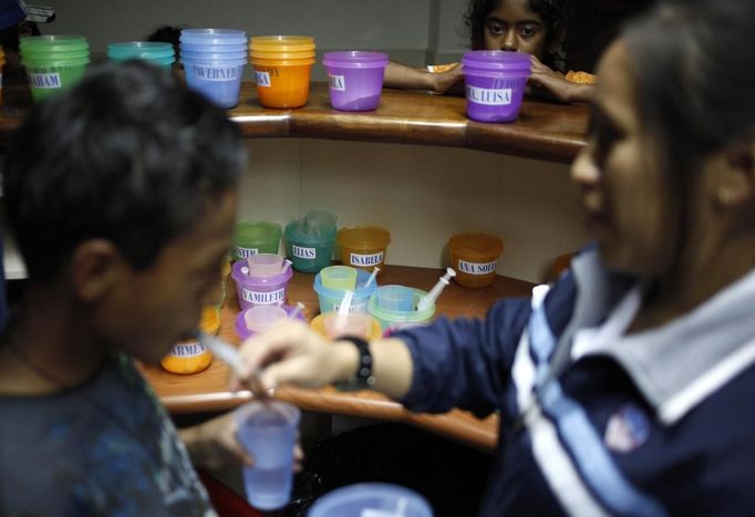 A nurse gives a child his medicine using a syringe in the San Jose Hospice, in Sacatepequez, 45 km (28 miles) of Guatemala City, November 30, 2012. About 68 HIV-infected children receive free medical care at the hospice, many of them were found abandoned in markets, churches, fire stations, left neglected in hospitals or in some instances, brought in by their families who cannot afford to pay for their medical treatment. World AIDS day which falls on December 1 is commemorated across the world to raise awareness of the pandemic. REUTERS/Jorge Dan Lopez (GUATEMALA - Tags: ANNIVERSARY HEALTH) Published: Pro. 1, 2012, 1:43 dop.