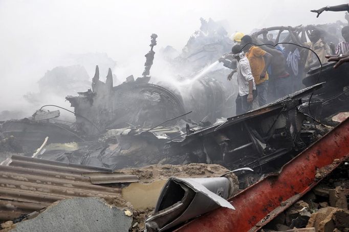 Emergency workers and volunteers hose down wreckage at the scene of a plane crash in Nigeria's commercial capital Lagos, June 3, 2012. A passenger plane carrying nearly 150 people crashed into a densely populated part of Lagos on Sunday, in what looked like a major disaster in Nigeria's commercial hub. There was no early word from airline or civil aviation authority officials in the West African country on casualties. REUTERS/Stringer (NIGERIA - Tags: DISASTER TRANSPORT TPX IMAGES OF THE DAY) QUALITY FROM SOURCE Published: Čer. 3, 2012, 6:39 odp.