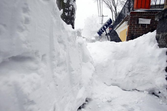 ¨ A woman works to clear snow from her sidewalk during a blizzard in Medford, Massachusetts February 9, 2013. A blizzard pummelled the Northeastern United States, killing at least one person, leaving hundreds of thousands without power and disrupting thousands of flights, media and officials said. REUTERS/Jessica Rinaldi (UNITED STATES - Tags: ENVIRONMENT) Published: Úno. 9, 2013, 3:13 odp.