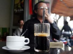 Muž kouří a popijí kávu v hanojské kavárně v den, kdy tým všdců zjisti riziko srdeční choroby u pijáků kafe.